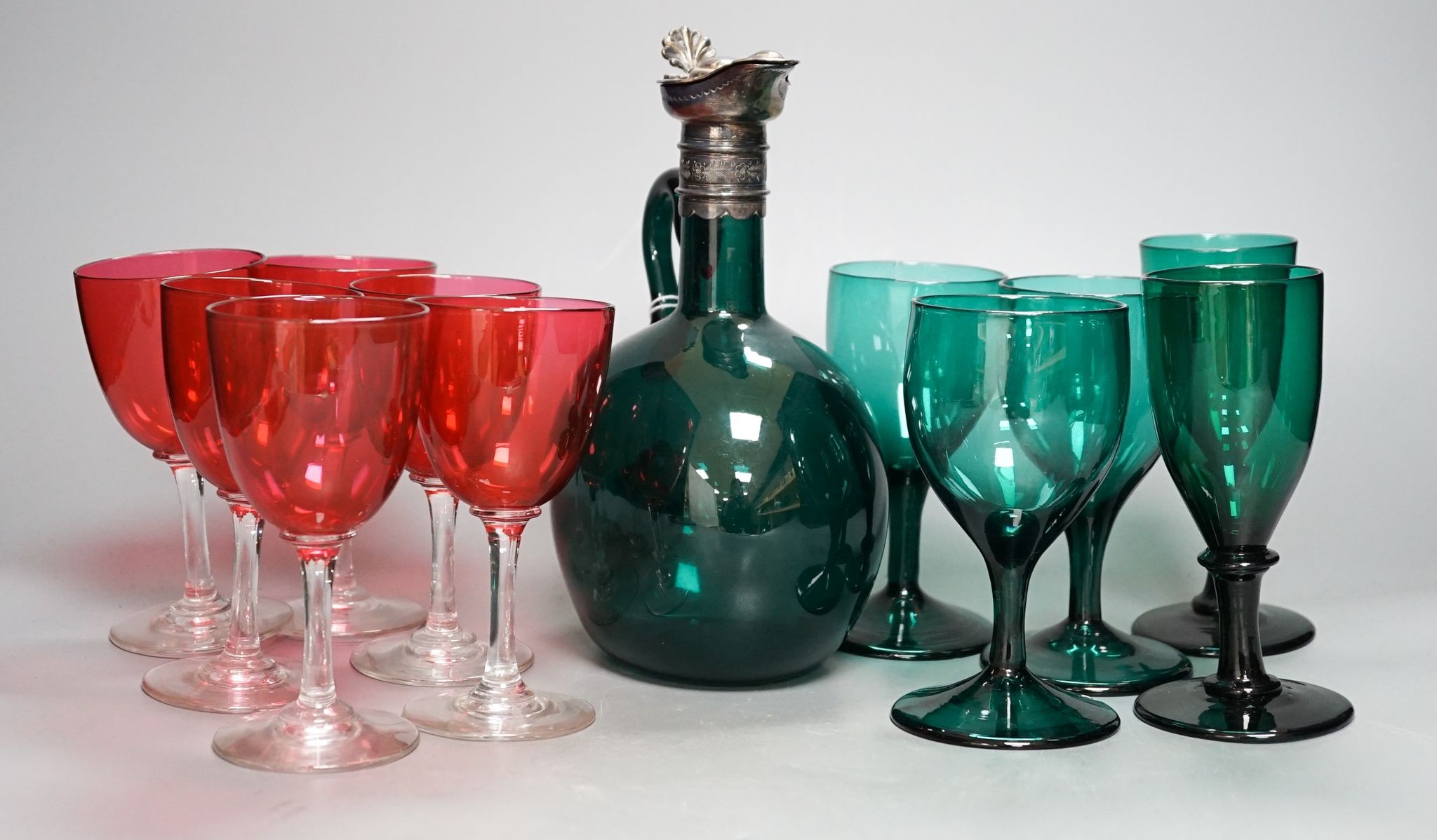 A Victorian dark green glass hock jug, five dark green wine glasses and 6 cranberry bowled wine glasses (12)
